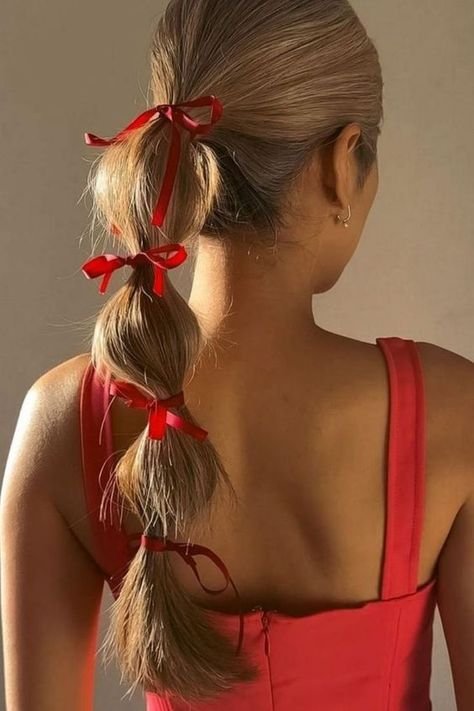 bubble ponytails with red bows
 https://outfitonpoint.com/effortlessly-elegant-christmas-hairstyles-for-your-holiday-soirees/